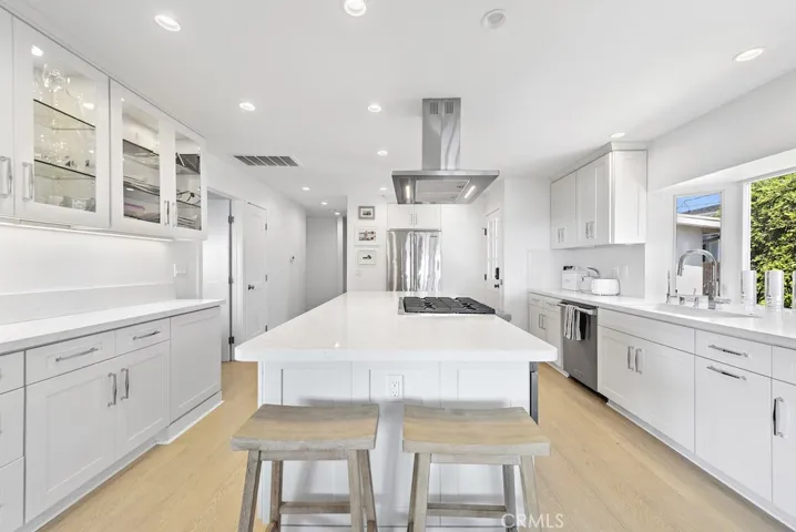 Kitchen complete with top of the line appliances including wine fridge and quartz counters with island and breakfast bar.