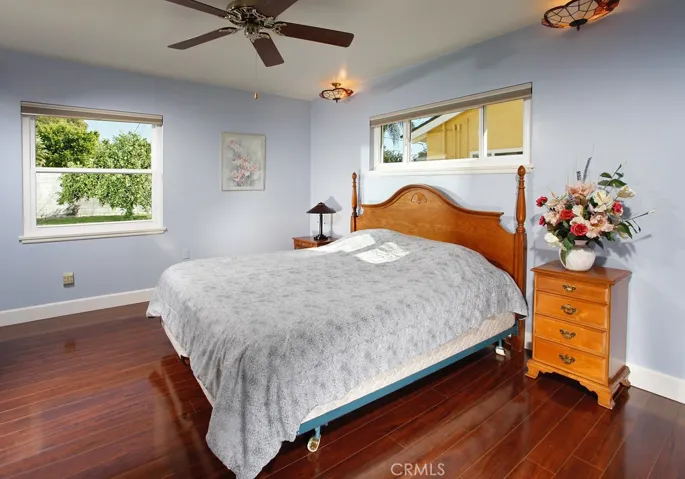 The bright and spacious master suite is enriched by picture windows, a ceiling fan, Tiffany style ceiling bedside lighting, ample closet space and gleaming oak hardwood floors.