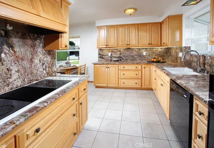 The cook in the family is going to truly appreciate the remodeled kitchen with its sparkling garden window, rich wood-grained cabinetry with deep pull-out drawers, over-the-counter lighting, walk-in pantry, granite counter-tops with rounded edges, full granite backsplash, dual basin undermount sink, pull-down faucet, modern electric cooktop with ventilation, Kitchenaid self-cleaning electric oven, Kenmore microwave oven, dishwasher, Frigidaire refrigerator/freezer with ice maker and easy care tiled floors:
