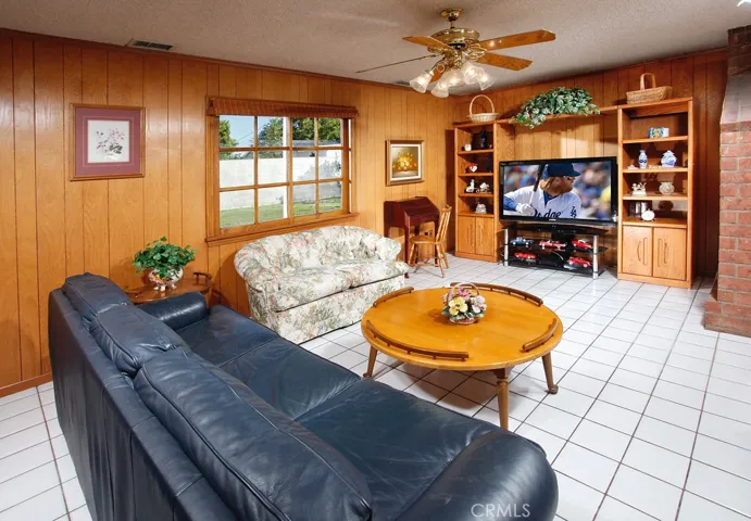 The expansive family room is bathed in natural light and is further enhanced with a lighted ceiling fan and tiled floors making it perfect for entertaining or quiet relaxation.