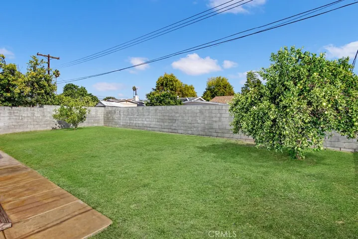 The private backyard will be a favorite entertainment destination with its sprawling green lawn, fruit trees and open patio.