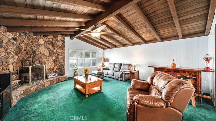 Huge family room with wood beamed ceiling, ceiling fan and cozy fireplace with heatilator