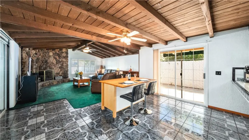 Dining area next to kitchen, with ceiling fan and slider to side