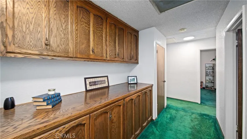 Extra wide hallway with lots of cabinet storage, two closets and whole house fan