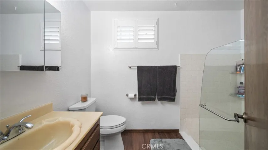 Primary bathroom with newer glass shower door and vinyl plank flooring