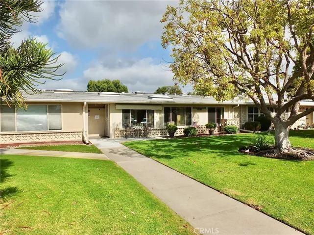 Pretty tree and lawn area lead you to the front door