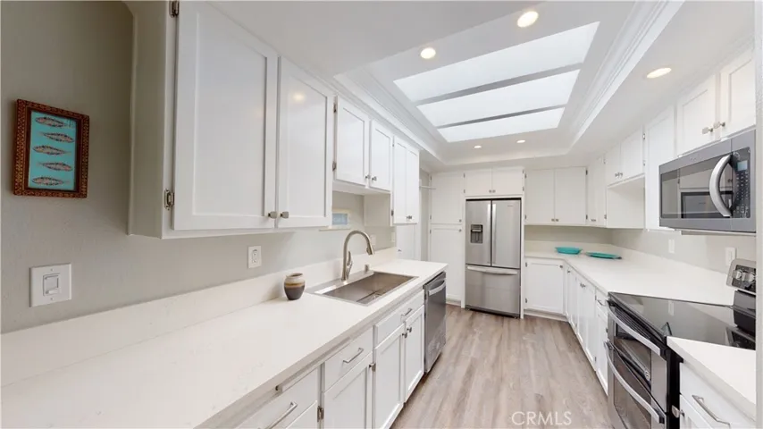 Natural light floods the kitchen from the huge skylight with recessed LED lights for evening time.