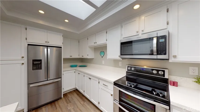 3 deep pantry storage cabinets adjacent brand new fridge.  Matching Whirlpool appliance package includes range/dual oven combo, microwave, and stainless interior dishwasher.
