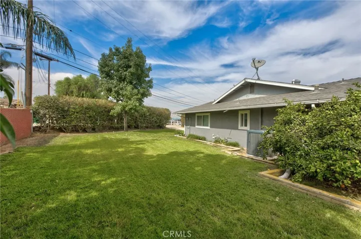 Side view of home with plenty of grass and fruit trees.