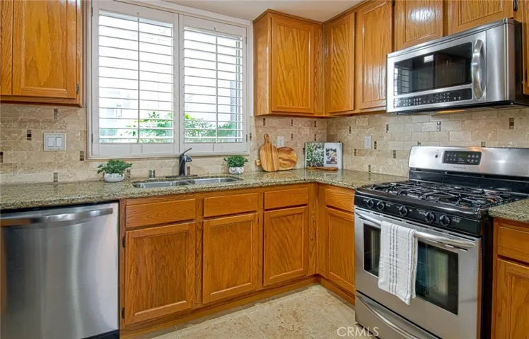 Upgraded tile backsplash with tasteful touches of sage and glistening granite countertops. 
