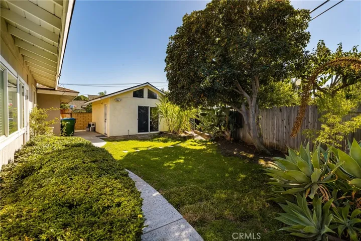 The side yard features mature plantings and access to the workshop.