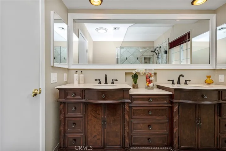 The vanity features an elegant burlwood finish and plenty of storage.