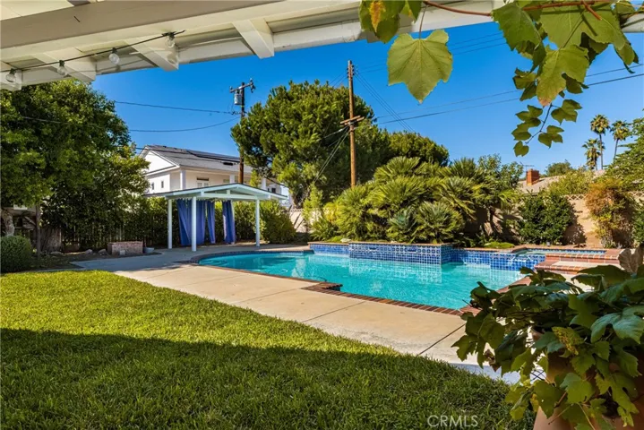 The large yard features lots of grass and multiple areas for everyone. From the covered patio to the pool and spa to the Gazebo and planting areas for vegetables.