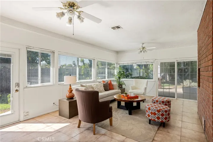 Adjacent to the formal living the the family room, surrounded on all sides by windows and featuring access to the yard.