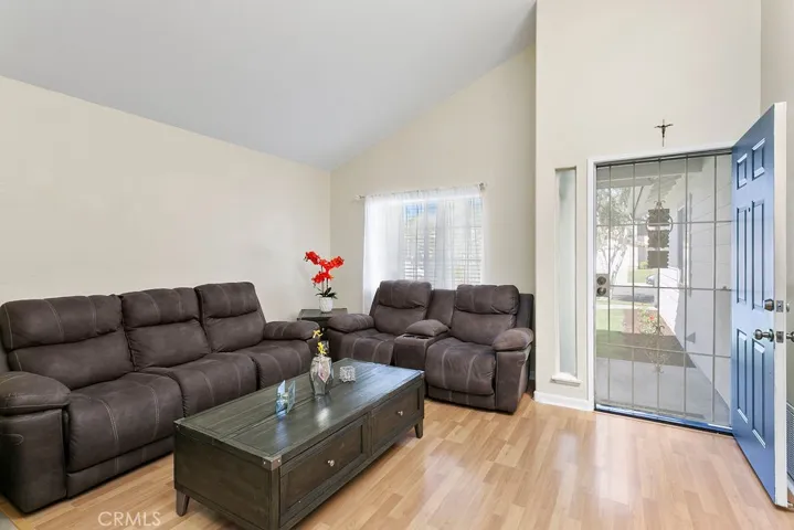 View of your living room with vaulted ceilings, front door & front window looking out to your front porch.