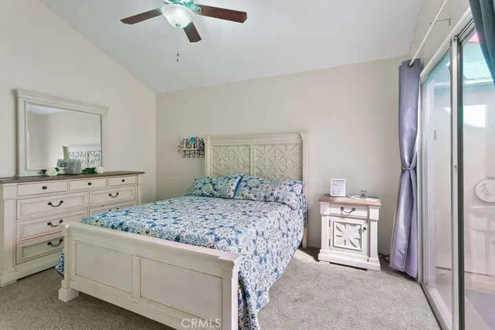 Secondary bedroom with vaulted ceiling, large closet, carpet & ceiling fan.