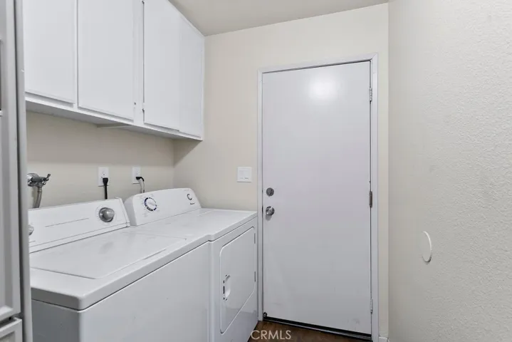 Inside laundry room with storage cabinets & laminate flooring with direct access to your 2 car attached garage.