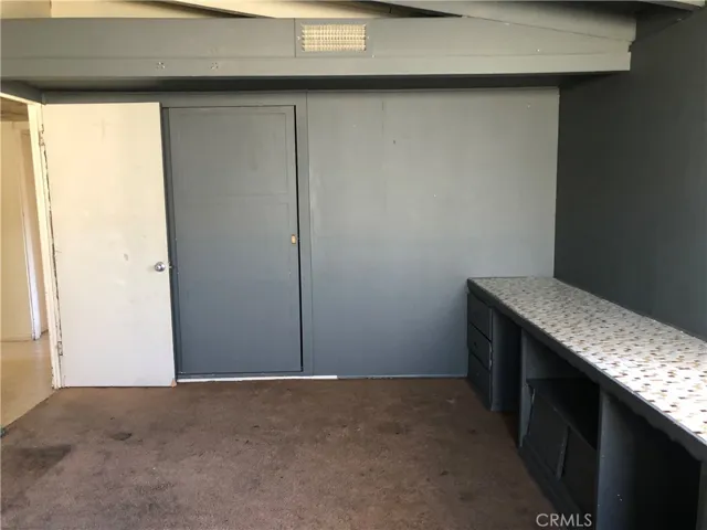 A secondary bedroom with a built-in desk.