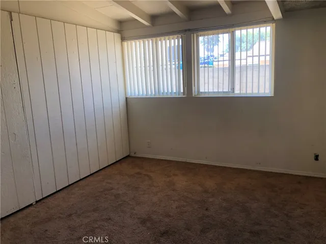 a secondary bedroom with one wall of wood paneling.