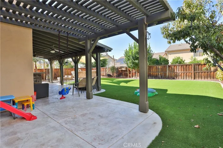 Beautifully landscaped with artificial turf and many fruit trees including avocado, apricot, and many others