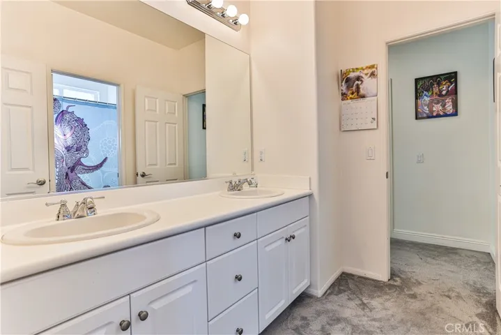 Upstairs bathroom with dual sinks and full bath