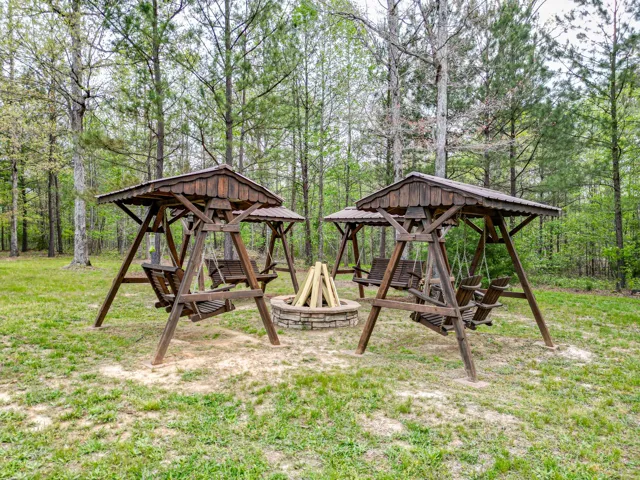Stone fire pit with covered swings