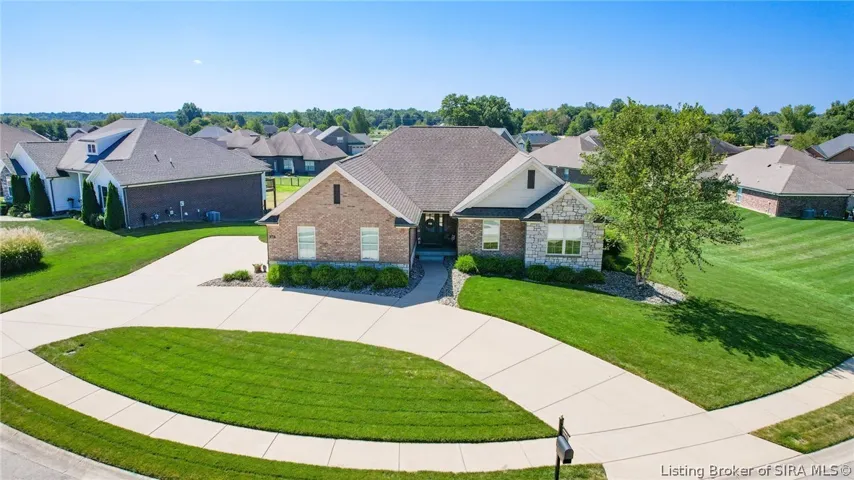 Drone view of front of home and beautiful landscaping