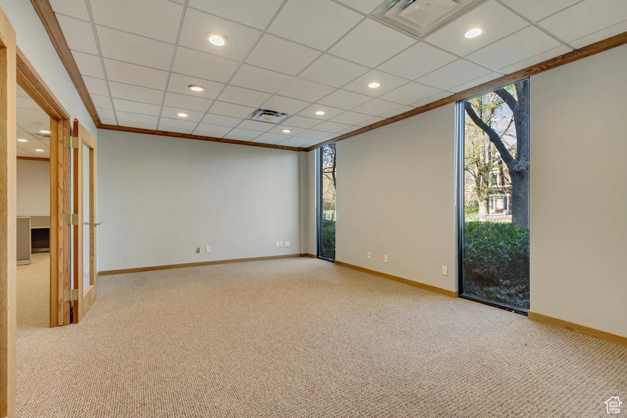 Spare room with carpet floors, visible vents, baseboards, and a wealth of natural light