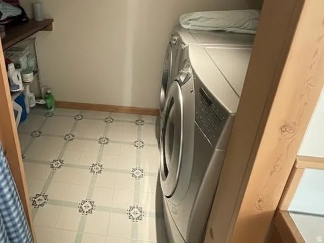 Dedicated laundry area featuring patterned tile flooring, recessed lighting, and integrated shelving
