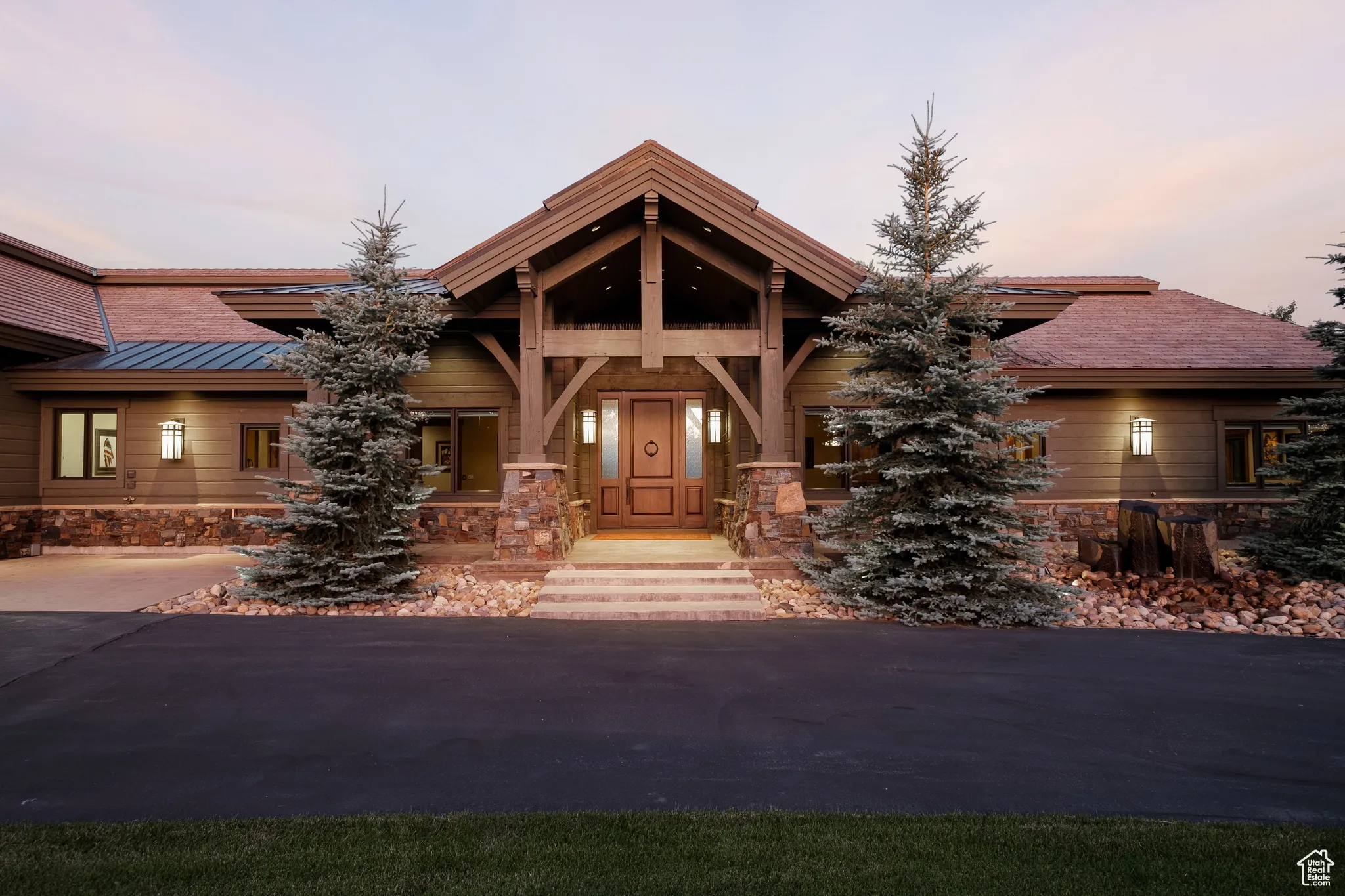 View of front facade with a standing seam roof, metal roof, and stone siding