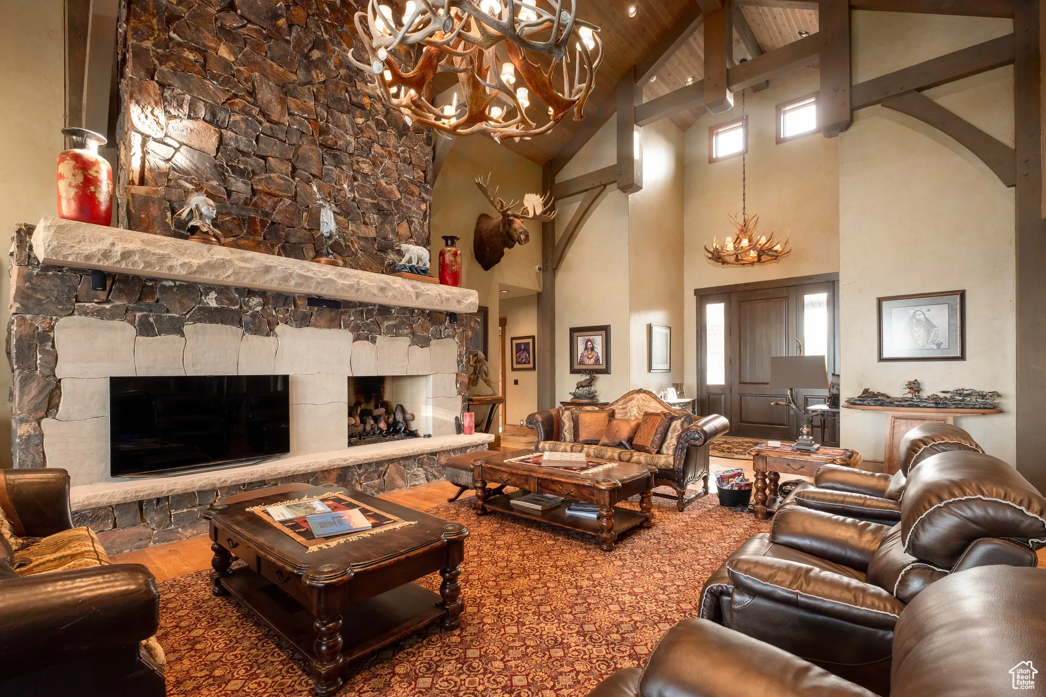 Living room featuring arched walkways, a fireplace, beam ceiling, high vaulted ceiling, and a notable chandelier