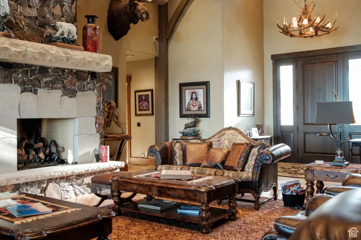 Living area with arched walkways, a high ceiling, a fireplace, and a notable chandelier