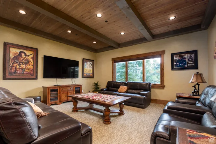 Living room featuring recessed lighting, beamed ceiling, light colored carpet, and wood ceiling