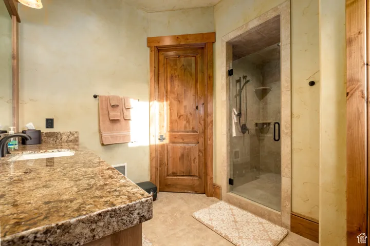 Full bathroom with vanity, a shower stall, and visible vents