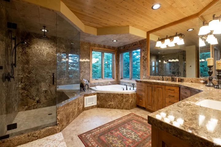 Bathroom with wood ceiling, a bath, visible vents, a shower stall, and vanity