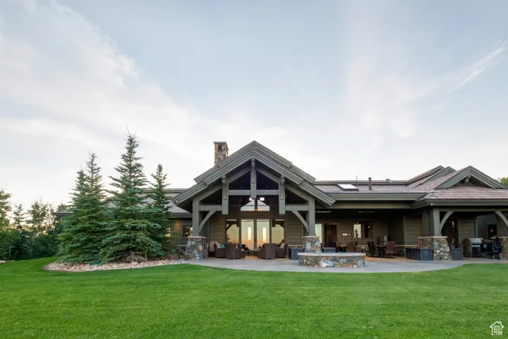 Back of house with a lawn, outdoor lounge area, a chimney, and a patio area