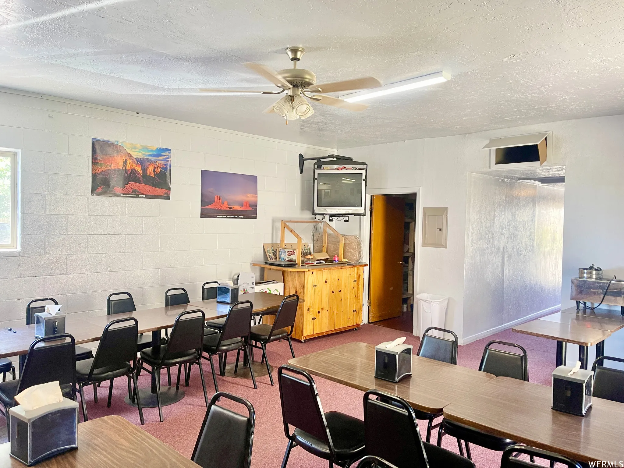 Home office featuring a ceiling fan and TV
