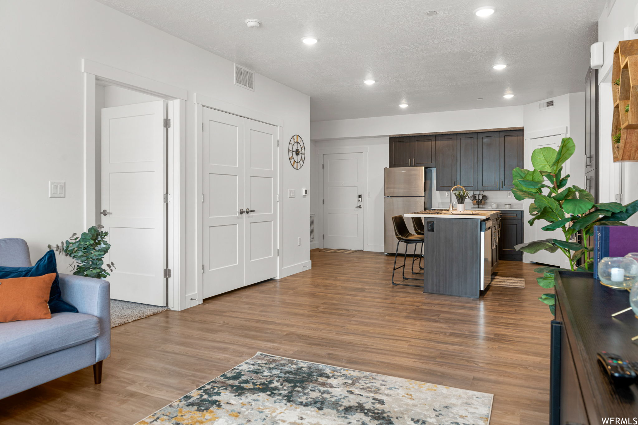 Kitchen featuring stainless steel fridge and light hardwood flooring