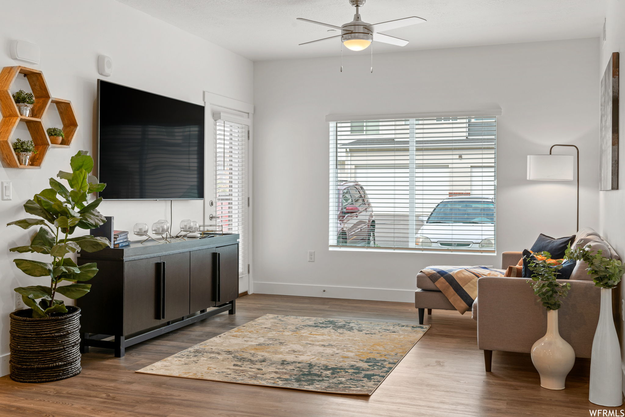 Hardwood floored living room featuring ceiling fan