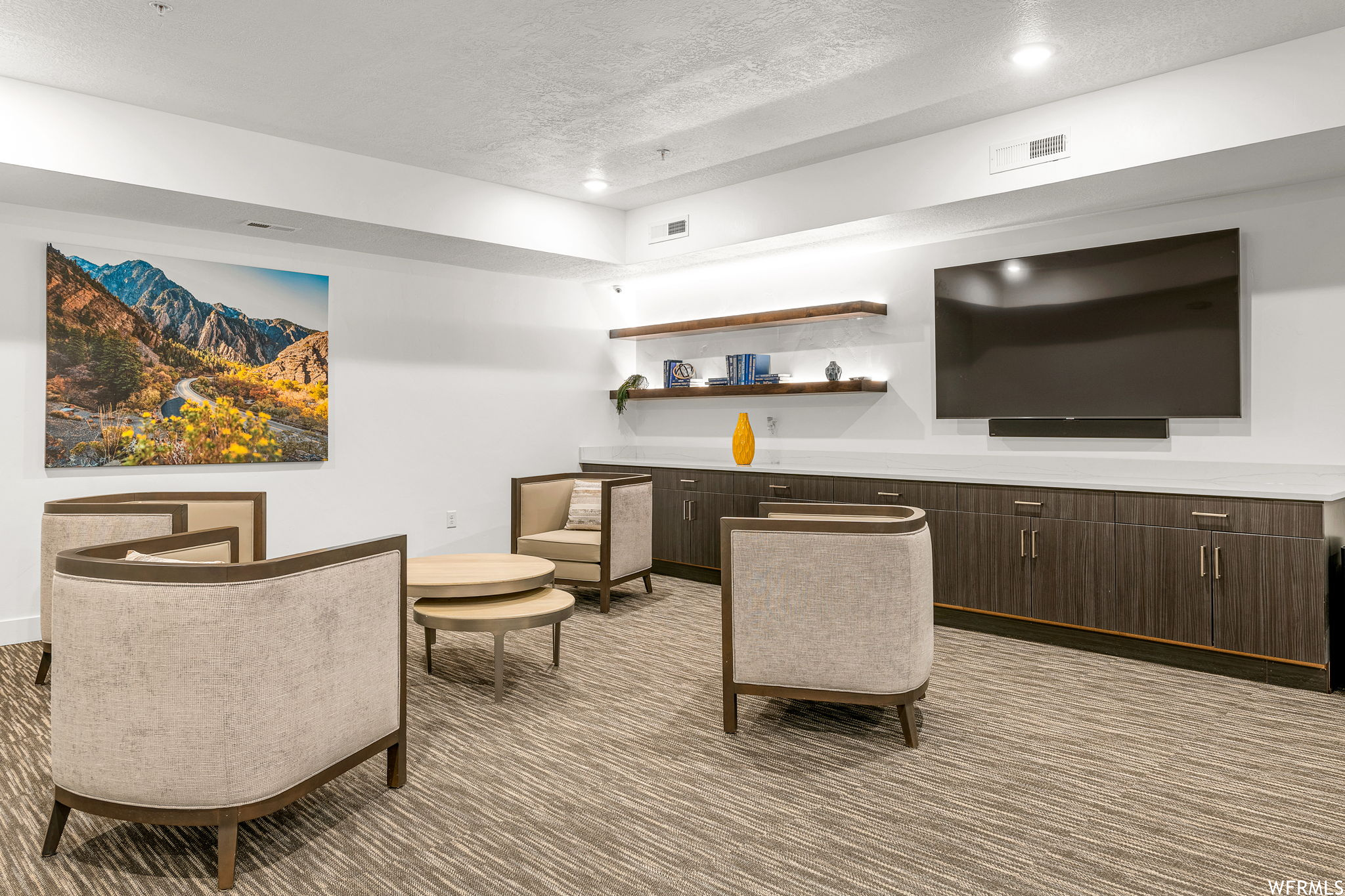 Carpeted living room with a textured ceiling