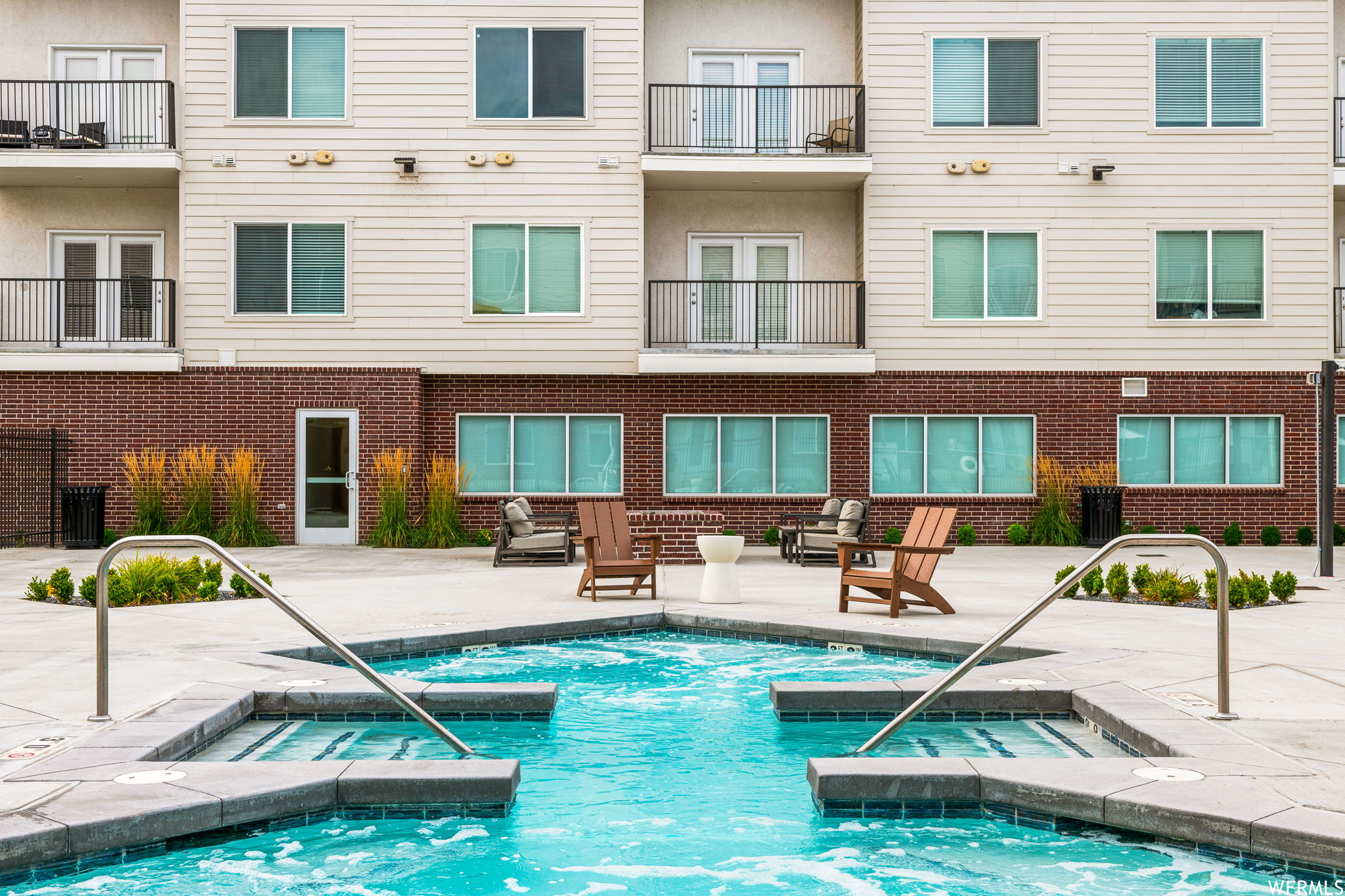 View of swimming pool with hot tub and a patio area