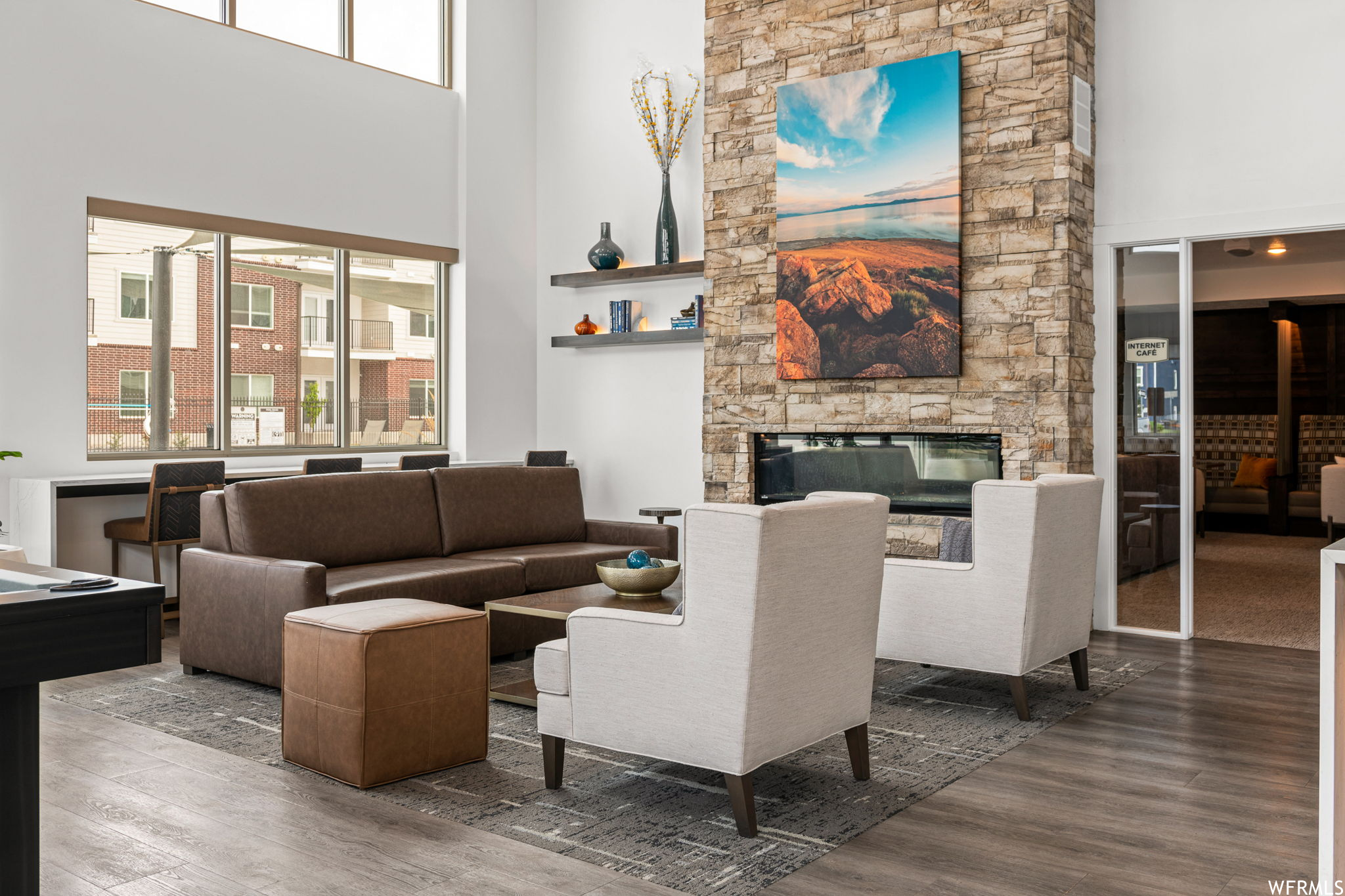Living room featuring a fireplace, a high ceiling, and dark hardwood flooring