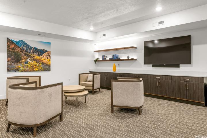 Carpeted living room with a textured ceiling