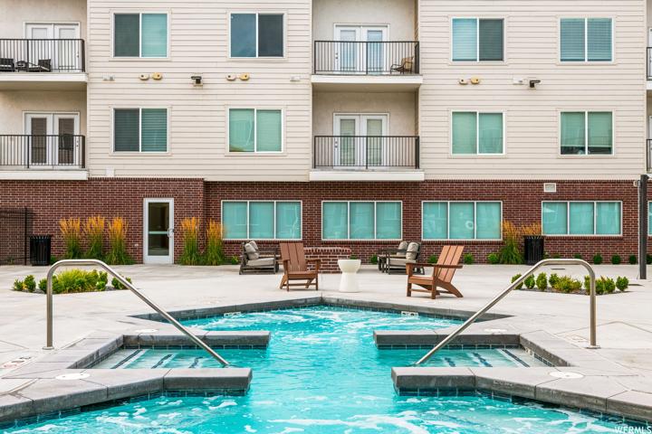 View of swimming pool with hot tub and a patio area