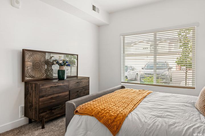 Bedroom featuring light carpet