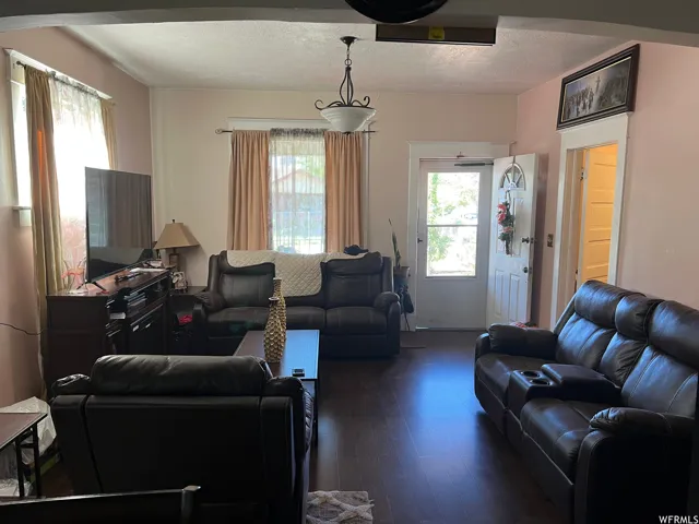 Living room featuring dark hardwood / wood-style flooring and a textured ceiling