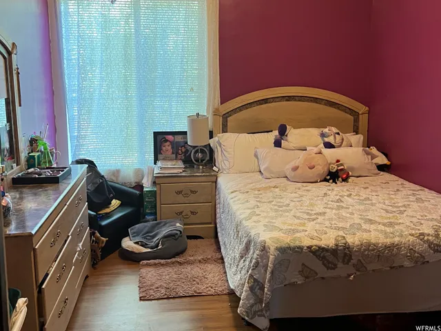 Bedroom with light wood-type flooring and a textured ceiling