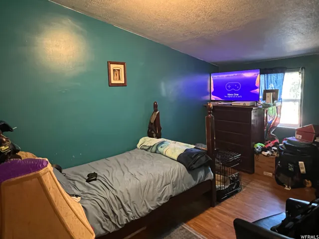 Bedroom with wood-type flooring and a textured ceiling