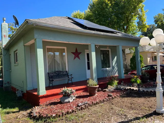 Bungalow-style home with solar panels and covered porch