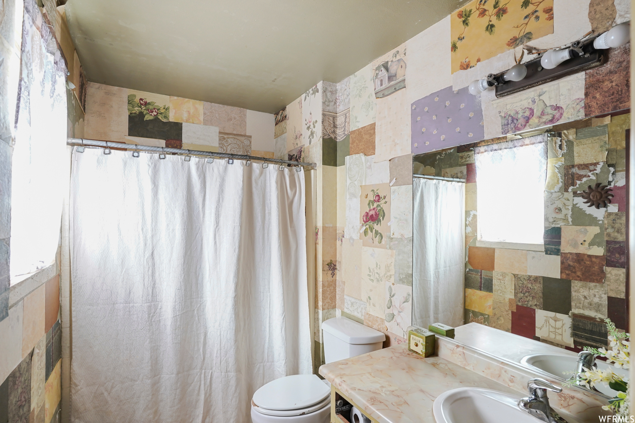 Bathroom with vanity, toilet, and tile walls